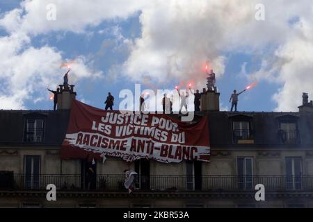 The tenants of the building of the penultimate floor tears the banner of the members of the extreme right group Generation Identitaire (GI) where it is said `` victims of anti-white racism '' during a demonstration `` Black Lives Matter '' against racism and police brutality, on the Place de la République in Paris on June 13, 2020. The banner which unfolded on the balcony below, was torn and cut by the residents of the apartment . (Photo by Mehdi Taamallah/NurPhoto) Stock Photo